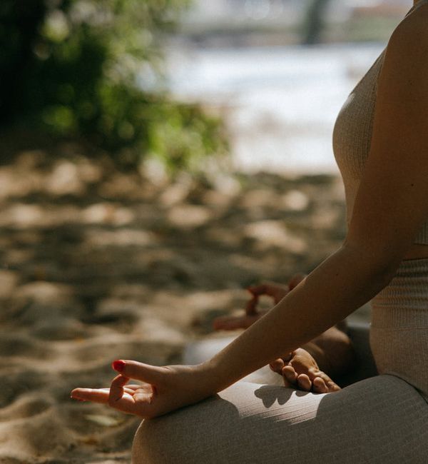 Person meditating peacefully in a serene natural environment.